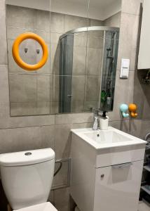 a bathroom with a white toilet and a sink at Lovely Jubbly Apartment in Krakow