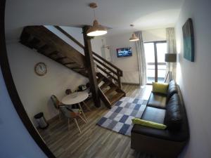 a living room with a couch and a table at Duplex Apartment Busteni in Buşteni