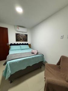 a bedroom with a large bed and a chair at Do mar ao Lar in Rio de Janeiro