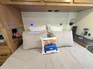 a bed with a pillow on it in a bedroom at Bumblebee - Luxury Destination Trailer in Canyon Lake