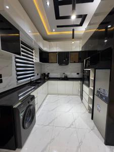 a large kitchen with a washer and dryer in it at Danjo Shortlets in Aja
