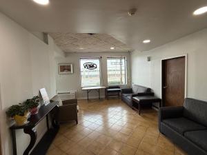 a waiting room with a couch and chairs and a table at Monte Mario Motel & Efficiency in Latham