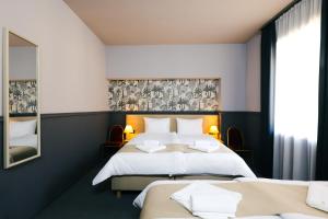 a hotel room with two beds and a mirror at Gartner Hotel in Budapest