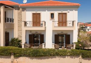 a large white house with a red roof at Iliodysi Houses in Methoni