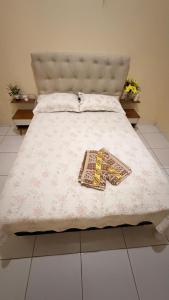 a bed with a white bedspread and a book on it at Casa Espaçosa e Aconchegante com 4 camas, 3 quartos in Juazeiro do Norte +32 photos