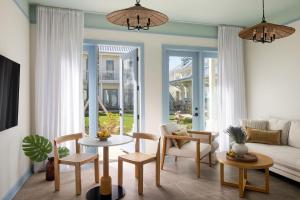 a living room with a couch and a table and chairs at The Pass Bungalows in Pass Christian