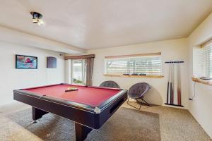 a red pool table in a room with two chairs at The Dockside Gamehouse in Olympia