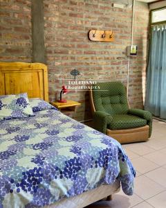 a bedroom with a bed and a green chair at Costa Azul 2 in Villa Pehuenia