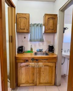 a kitchen with wooden cabinets and a sink at Costa Azul 2 in Villa Pehuenia