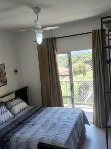a bedroom with a bed and a large window at Refúgio perfeito em Itatiba in Itatiba