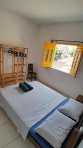 a bedroom with two beds and a window at Casa Relva Suítes in Lençóis