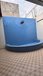 a blue bench on the side of a building at Casa Espaçosa e Aconchegante com 4 camas, 3 quartos in Juazeiro do Norte