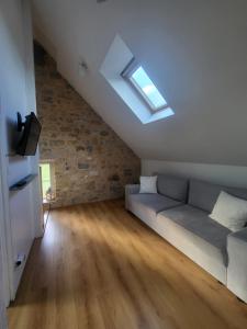 a living room with a couch and a skylight at La Forge, gîte familial,à Sainte Mère Eglise in Sainte-Mère-Église