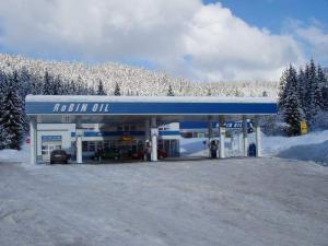 a gas station with a blue roof in the snow at ČS RoBiN OIL Harrachov in Harrachov