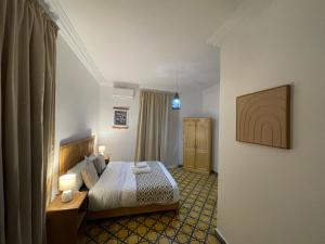 a hotel room with a bed and a desk in it at La Perle d'Argan in Essaouira