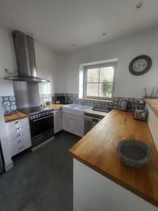 a kitchen with a stove and a counter top at La Forge, gîte familial,à Sainte Mère Eglise in Sainte-Mère-Église
