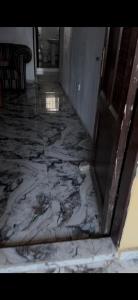 a hallway with a marble floor with a door at Rehoboth compound in Lekki