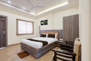 a bedroom with a large bed and a chair at Hotel O Rajdhani Heritage in Nāmkom