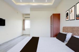 a bedroom with a large bed and a tv at Hotel O Rajdhani Heritage in Nāmkom