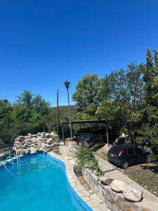 a swimming pool with two cars parked in a yard at Posada Bella Vista 1 y 2 in El Volcán