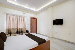 a bedroom with a bed and a flat screen tv at Hotel O Rajdhani Heritage in Nāmkom