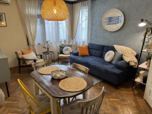 a living room with a blue couch and a table at Vanito Art Escape in Nesebar