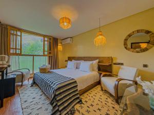 a bedroom with a bed and a table and a mirror at Targa Imoula Luxe in Imlil