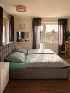 a bedroom with a large bed with a large window at Agroturystyka Parlińskie Wody II in Parlino