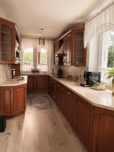 a kitchen with wooden cabinets and a large kitchen island at Agroturystyka Parlińskie Wody II in Parlino