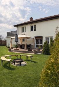 a house with two picnic tables in the yard at Agroturystyka Parlińskie Wody II in Parlino