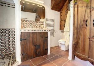 a bathroom with a toilet and a wooden door at Casa MaLuMi - Historisches Stadthaus in Haría in Haría