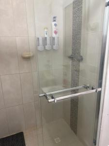 a shower with a glass door with a hand rail at Playa dorodo in La Chorrera +39 photos