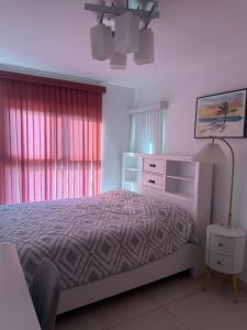 a bedroom with a bed and a dresser and a lamp at Playa dorodo in La Chorrera