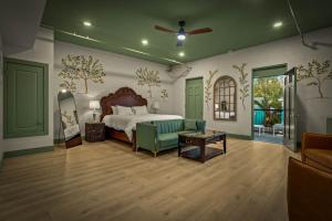 a bedroom with a bed and a couch and a table at Hotel Mojo in Ocean Springs