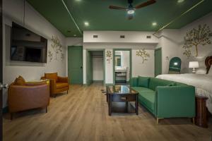 a hotel room with a bed and a couch and chairs at Hotel Mojo in Ocean Springs