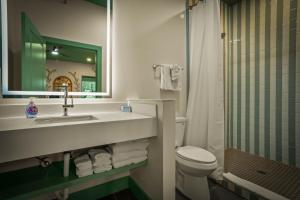 a bathroom with a sink and a toilet and a mirror at Hotel Mojo in Ocean Springs +90 photos