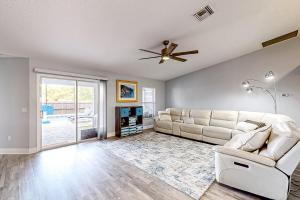 a living room with a couch and a ceiling fan at Poolside Oasis! Family-Friendly Summerfield Escape in Orange Blossom Hills