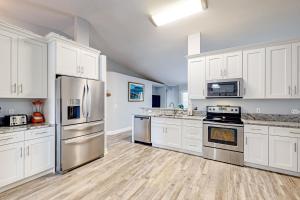 a kitchen with white cabinets and stainless steel appliances at Poolside Oasis! Family-Friendly Summerfield Escape in Orange Blossom Hills