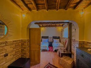 a living room with a couch and a stone wall at Targa Imoula Luxe in Imlil