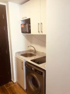 a kitchen with a washing machine and a sink at فلورنزا خمسين in Hurghada