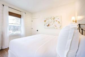 a white bedroom with a bed and a window at Kildahl House - Boutique Farmhouse Suite #4 in West Dundee