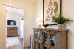 a living room with a wooden cabinet and a television at Kildahl House - Boutique Farmhouse Suite #4 in West Dundee