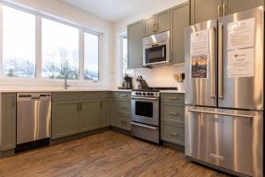 a kitchen with stainless steel appliances and wooden floors at Powder House Chalet by Fernie Central Reservations in Fernie