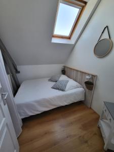 a bedroom with a bed with a window and a mirror at La Forge, gîte familial,à Sainte Mère Eglise in Sainte-Mère-Église