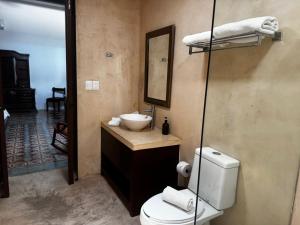 a bathroom with a toilet and a sink and a mirror at Boutique Casa Azuli Santiago in Mérida +41 photos