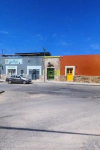 ein Auto, das auf einem Parkplatz neben einem Gebäude geparkt ist in der Unterkunft Tiny Room Historic Center in Hermosillo