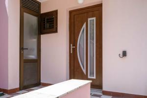 a front door of a house with wooden doors at Apartmani Antula in Prigradica