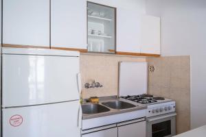 a kitchen with a white refrigerator and a sink at Apartmani Antula in Prigradica +58 photos
