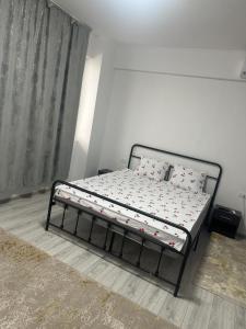 a bed in a white room with a bed frame at Garsonieră in Tulcea