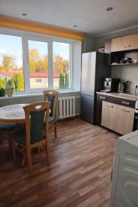 a kitchen with a table and a refrigerator at Apartamenti dzīvoklis Ogre. in Ogre